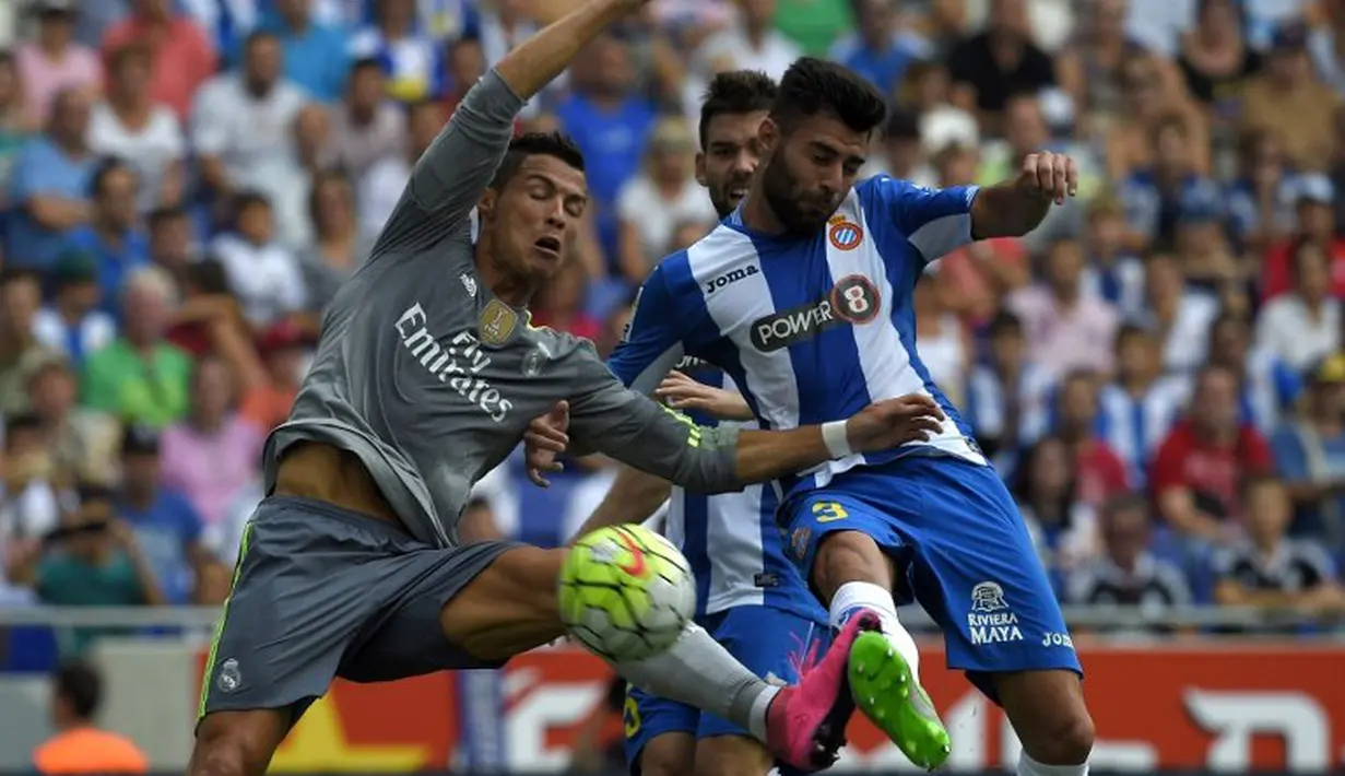 Cristiano Ronaldo berebut bola dengan pemain Espanyol, Ruben Duarte, dalam lanjutan La Liga Spanyol di Stadion Cornella El Prat, Espanyol. Sabtu (12/9/2015). (AFP Photo/Lluis Gene)