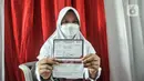 Seorang murid menunjukkan Kartu Vaksinasi COVID-19 di SDN Cempaka Putih Timur 03 Pagi, Jakarta, Selasa (14/12/2021). Pemerintah menyiapkan 58 juta dosis vaksin COVID-19 untuk anak usia 6-11 tahun. (merdeka.com/Iqbal S. Nugroho)
