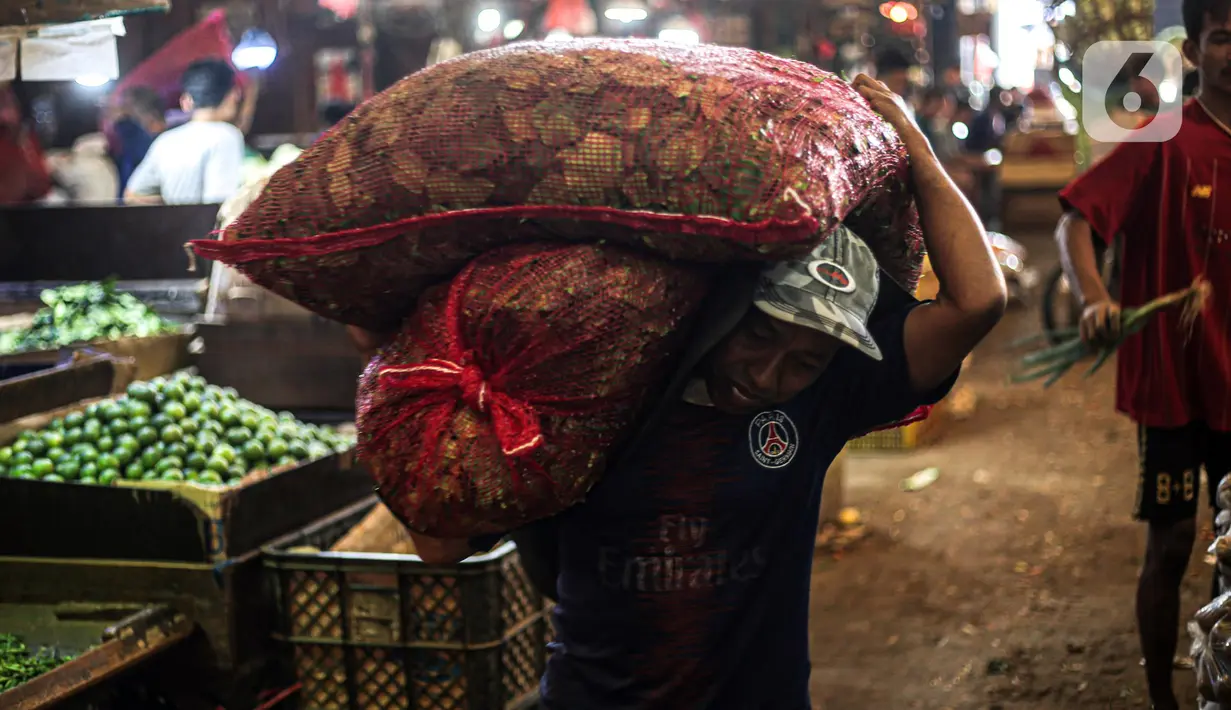 Pekerja memikul karung di Pasar Induk Kramat Jati, Jakarta, Kamis (29/12/2022). Rencananya, revitalisasi Pasar Kramat Jati ini akan selesai sekitar 18 bulan. (Liputan6.com/Faizal Fanani)