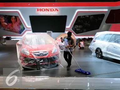 Pekerja membersihkan salah satu booth produsen mobil peserta pameran Indonesia Internasional Motor Show 2015 di JIExpo Kemayoran, Jakarta, Selasa (18/8/2015). Sekitar 50-an brand mobil ternama akan ramaikan IIMS 2015. (Liputan6.com/Helmi Fithriansyah)
