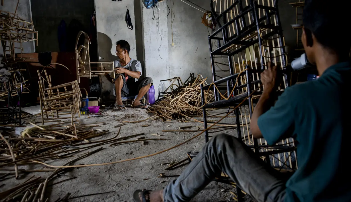 Pekerja menyelesaikan pembuatan stand dari rotan yang digunakan untuk hadiah selama bulan suci Ramadhan di gudang home industri di Banda Aceh (24/4/2021). (AFP/Chaideer Mahyuddin)