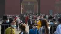 Pengunjung mengenakan masker untuk mencegah penyebaran virus corona keluar dari Kota Terlarang di Beijing, Rabu, (7/10/2020). Menurut kementerian budaya dan pariwisata China, libur Hari Nasional menghasilkan $ 45,9 miliar pendapatan pariwisata. (AP Photo/Andy Wong)