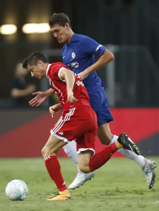 Striker Bayern Munchen, Robert Lewandowski, berebut bola dengan bek Chelsea, Andreas Christensen pada laga turnamen pramusim ICC 2017 di Stadion Nasional Singapura, Selasa (25/7/2017). Bayern Munchen menang 3-2 atas Chelsea. (EPA/Wallace Woon)