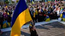 Seorang gadis memegang bendera Ukraina saat warga Ukraina dan pendukung mereka berkumpul untuk memperingati satu tahun invasi Rusia ke Ukraina di Tel Aviv, Israel, 24 Februari 2023. (AP Photo/Ariel Schalit)