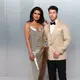 Pasangan power couple, Priyanka Chopra dan Nick Jonas, kembali membuktikan status mereka sebagai fashion icon. Priyanka mengenakan gaun metalik rancangan Stella McCartney dengan aksen fur yang dramatis, sementara Nick tampil sleek dalam tuxedo krem yang clean. Keduanya menghadirkan harmoni antara bold femininity dan refined masculinity.