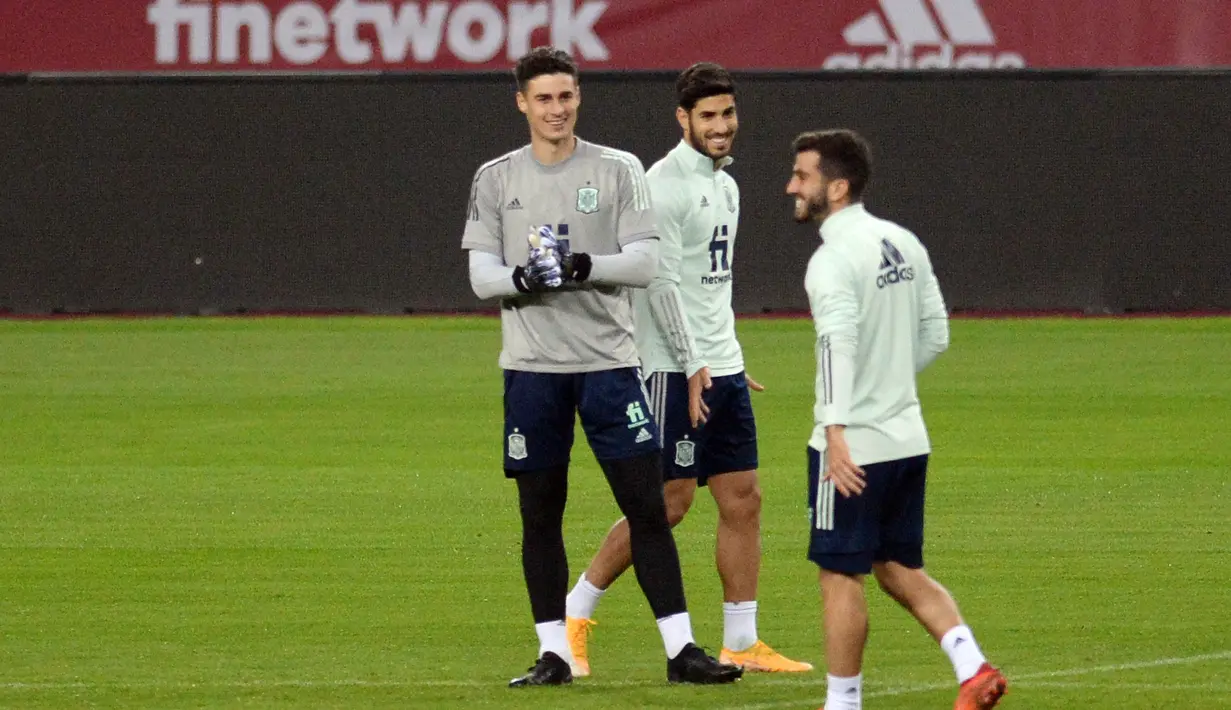 Penjaga gawang Spanyol Kepa Arrizabalaga (kiri) dan penyerang Spanyol Marco Asensio (tengah) menghadiri sesi latihan di stadion La Cartuja di Seville (17/11/2020). Pemenang laga antara Spanyol vs Jerman dipastikan menjadi pimpinan klasemen Grup A4. (AFP/Cristina Quicler)