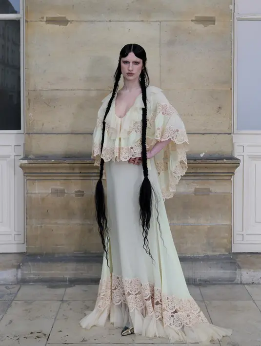 Tali Lennox menghadirkan kombinasi boho-goth dalam balutan gaun chiffon, renda, dan tulle dari Valentino. Tampilan ini memancarkan aura ethereal namun tetap edgy, berkat gaya rambutnya yang semakin menegaskan sisi gelap dari estetika romantisnya. Nuansa gothic yang ia bawa terasa begitu kuat, dan ini menjadi salah satu tampilan yang paling menarik perhatian. [Dok/Valentino].