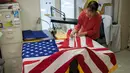Seorang pekerja menyelesaikan pembuatan Bendera Amerika Serikat di Alexandria Virginia, AS (10/1). Upacara pengambilan sumpah presiden dan wakil presiden baru AS akan digelar di sisi barat gedung Capitol AS. (AFP/Andrew Caballero Reynolds)