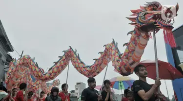 Atraksi liong saat perayaan Cap Go Meh Tahun Baru Imlek 2571 di Jatinegara, Jakarta, Minggu (9/2/2020). Meski hujan, perayaan Cap Go Meh berlangsung meriah dengan atraksi barongsai dan liong serta arakan dewa-dewa (rupang), mengelilingi kawasan Jatinegara. (merdeka.com/Iqbal S Nugroho)