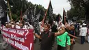 Massa membawa bendera dan spanduk saat melintas di Jalan Medan Merdeka Selatan, Jakarta, (4/11). Dalam aksinya, massa menuntut agar polisi segera menangkap Gubernur Nonaktif Basuki T Purnama atas dugaan penistaan agama. (Liputan6.com/Immanuel Antonius)