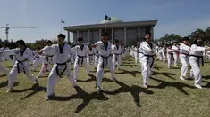 Peserta memperagakan seni bela diri taekwondo di depan Gedung Majelis Nasional Korea Selatan, Seoul, 21 April 2018. Ada 8.212 peserta yang memperagakan poomsae, pola gerakan pertahanan dan serangan, tanpa putus serta berkesinambungan. (AP/Lee Jin-man)