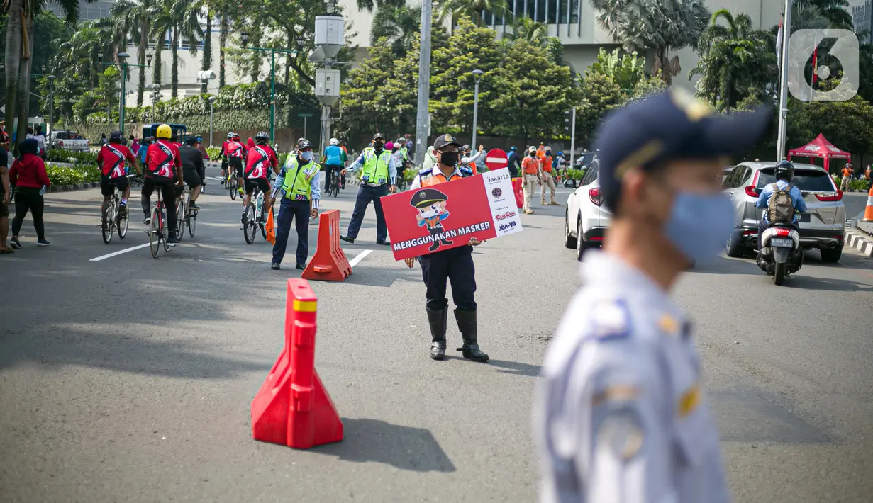 Petugas Dishub dan Satpol PP DKI Jakarta mensosialisasikan protokol kesehatan 3M di kawasan Bundaran HI, Jakarta Pusat, Minggu (8/11/2020). Pemprov DKI Jakarta memastikan masa Pembatasan Sosial Berskala Besar transisi yang berakhir pada hari ini kembali diperpanjang. (Liputan6.com/Faizal Fanani)
