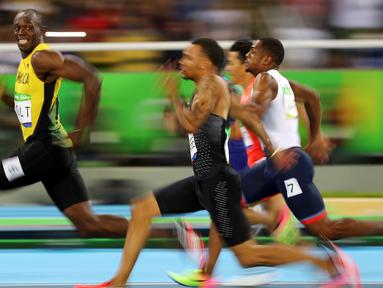 Usain Bolt menoleh sekaligus mengajak berbincang lawannya saat berlaga di Olimpiade Rio 2016, Brasil pada 14 Agustus 2016. Bolt berhasil meraih medali emas dalam cabang olahraga atletik 100 meter putra. (REUTERS/Kai Pfaffenbach)      