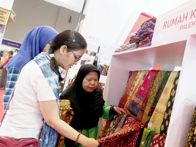 Pengunjung melihat produk Rumah Kain Palembang di booth YDBA pada Jakarta Fair Kemayoran 2019 di JIExpo Kemayoran, Jakarta, Rabu (19/6/2019). YDBA mengikutsertakan 40 UMKM mulai dari produk fashion, aksesoris, kerajinan, alat rumah tangga hingga makanan hingga 30 Juni 2019. (Liputan6.com/HO/Eko)