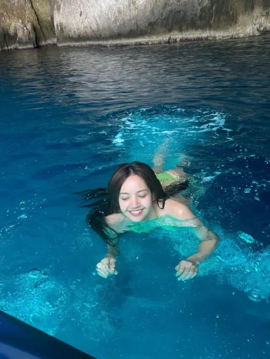 Lisa berenang di air yang berwarna biru jernih. Dengan mengenakan bikini two pieces, penyanyi kelahiran Thailand ini tampak rileks merasakan sejuknya air.