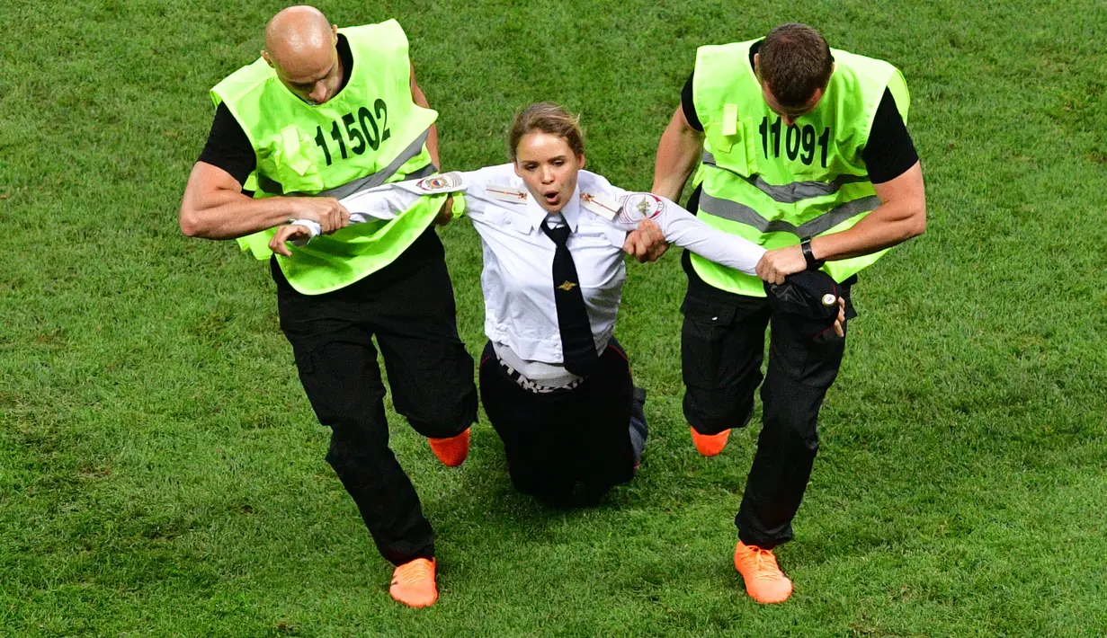 Seorang wanita yang tergabung dalam kelompok aktivis Pussy Riot diamankan usai menyusup saat laga final Piala Dunia 2018 antara Prancis vs Kroasia sedang berlangsung di Luzhniki Stadium, Rusia. ( AFP/Mladen Antonov )