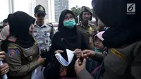 Petugas Satpol PP meminta pengunjung mengganti pakaian bertagline '#2019GantiPresiden' yang dikenakannya selama car free day (CFD), Jakarta, Minggu (6/5). CFD tidak boleh dimanfaatkan untuk kepentingan partai politik dan SARA. (Merdeka.com/Iqbal Nugroho)