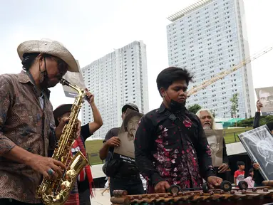 Seniman memainkan alat musik saat mengikuti Karnaval Seni Budaya di Taman Ismail Marzuki, Jakarta, Rabu (10/11/2021). Karnaval tersebut menampilkan pertunjukan seni budaya digelar sebagai rangkaian perayaan HUT ke-53 Taman Ismail Marzuki (TIM). (Liputan6.com/Herman Zakharia)