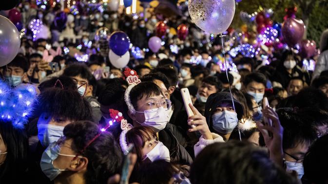 Orang-orang menghadiri hitung mundur di Wuhan, provinsi Hubei, China (1/1/2021). Beberapa warga Wuhan mengatakan mereka berhati-hati, tetapi sebagaian tidak khawatir tertular Covid-19. (AFP/Noel Celis)