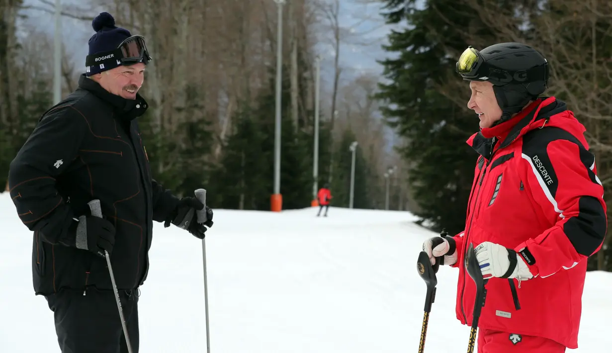 Presiden Rusia Vladimir Putin (kanan) dan Presiden Belarus Alexander Lukashenko berbincang saat bermain ski bersama di Gazprom Mountain Resort dekat resor Laut Hitam Sochi, Rusia, Rabu (13/2). (Mikhail KLIMENTYEV/SPUTNIK/AFP)