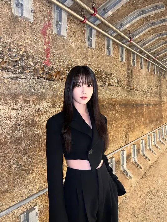 Pesona misterius IU dengan rambut panjang lurus berponi dan berwarna hitam. Penampilannya semakin kontras dengan pulasan lipstik merah glossy yang dikenakannya. [Foto: Instagram/dlwlrma]
