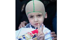 Ahmed Dawabsha adalah bocah berusa 5 tahun yang selamat dari bom di Palestina mengenakan bendera Real Madrid saat tiba di Bandara Adolfo Suarez, Madrid, Rabu (16/3/2016).  (AFP/Curto De La Torre)