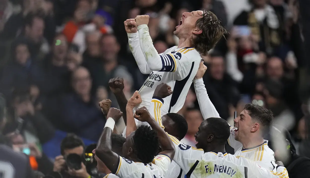 Ekspresi bahagia pemain Real Madrid, Luka Modric saat melakukan selebrasi bersama rekan-rekannya setelah mencetak gol ke gawang Sevilla pada laga lanjutan Liga Spanyol 2023/2024 di Stadion Santiago Bernabeu, Madrid, Spanyol, Senin (26/02/2024) dini hari WIB. Los Blancos menang dengan skor 1-0. (AP Photo/Manu Fernandez)