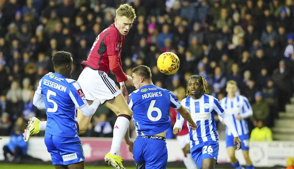 Pemain Manchester United, Scott McTominay, berusaha mencetak gol ke gawang Wigan Athletic dalam laga putaran ketiga FA Cup 2023/2024 di DW Stadium, Selasa (9/1/2024) dini hari WIB. Kemenangan ini membawa Manchester United melaju ke putaran keempat. (AP Photo/Jon Super)