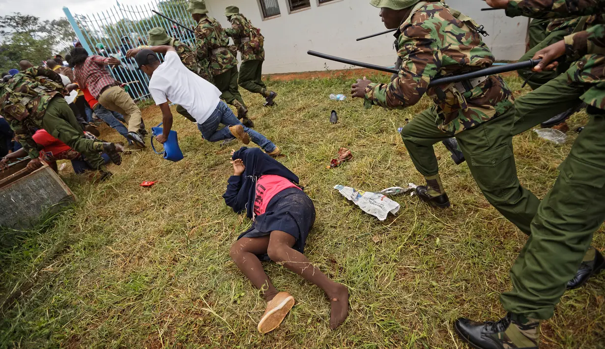 Seorang wanita tergeletak saat terjadi bentrokan antara pendukung Presiden Uhuru Kenyatta dan polisi di Nairobi, Kenya (28/11). Sebelumnya, pemilihan Presiden Kenya pada tahun ini penuh dengan kontroversi. (AP Photo / Ben Curtis)