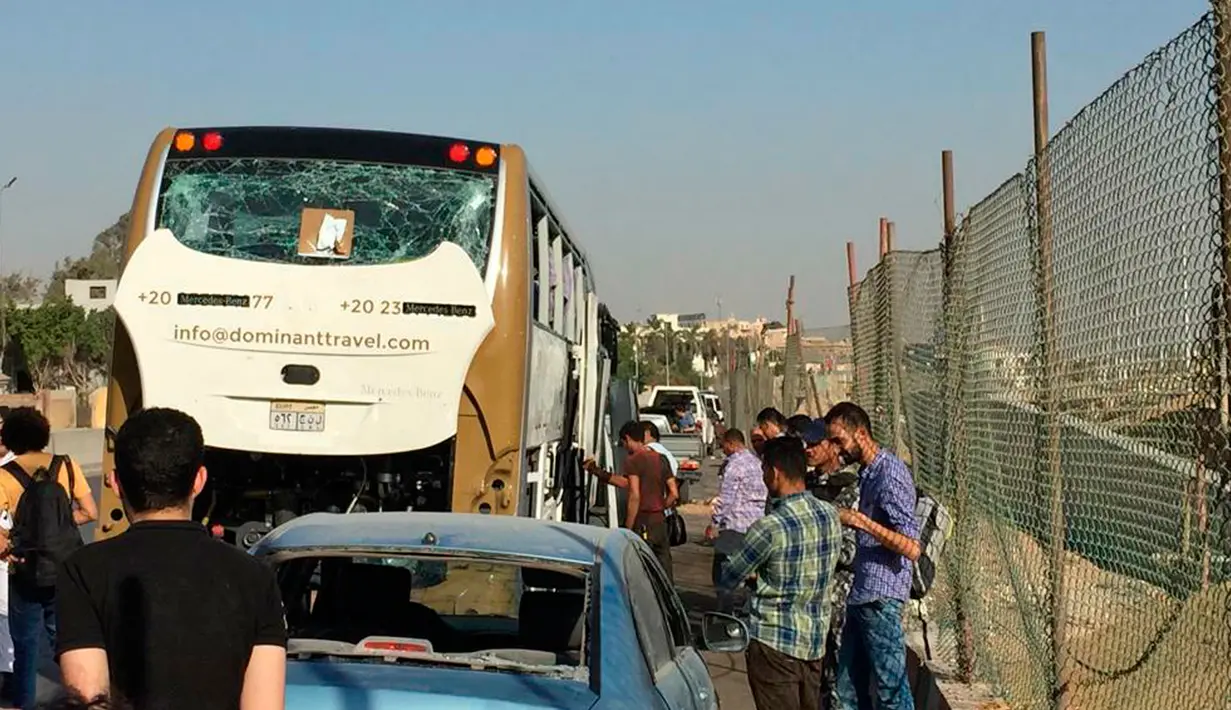 Bus wisata dan mobil yang rusak setelah ledakan bom terparkir di pinggir jalan dekat Piramida Giza, Kairo, Minggu (19/5/2019). Menurut sumber keamanan, para korban luka kebanyakan dikarenakan akibat terkena pecahan kaca. (AP Photo/Mohammed Salah)