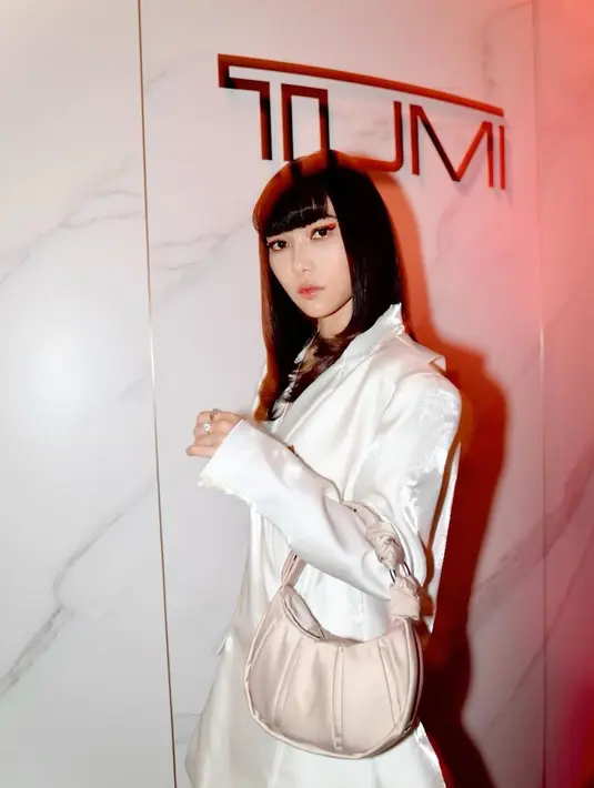 Isyana tampil dengan gaya glamor chic mengenakan cut out suit warna putih. [@isyanasarasvati]