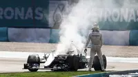 Pebalap Mercedes, Lewis Hamilton, memandangi mobilnya yang berasap setelah mesinnya jebol saat sedang memimpin balapan F1 GP Malaysia di Sirkuit Sepang, Malaysia, Minggu (2/10/2016). (Autosport)
