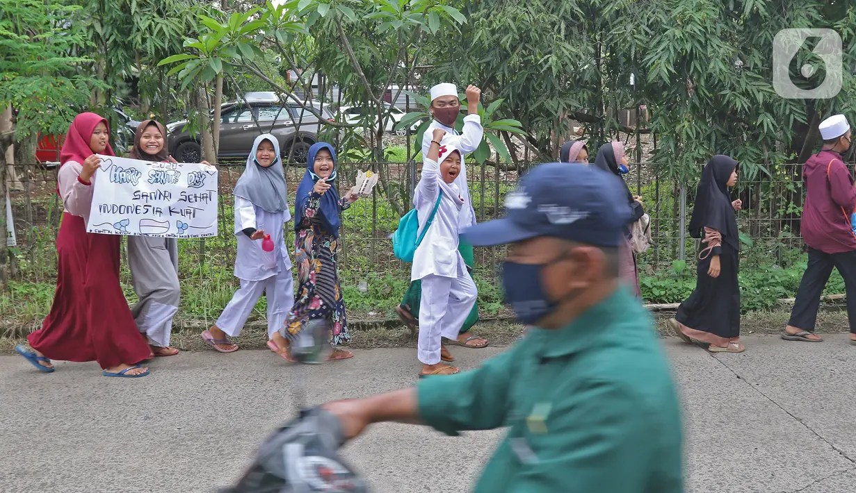 Sejumlah anak pengajian melakukan pawai di Jalan Raya Tapos, Depok, Jawa Barat, Kamis (22/10/2020). Pengajian Kampung Tapos menggelar pawai menyambut Hari Santri Nasional 2020 yang diperingati setiap tanggal 22 Oktober. (Liputan6.com/Herman Zakharia)