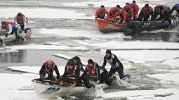 Tim Latulippe dilewati oleh Tony Allaire (belakang) bergerak melalui air es pada perlombaan kano es Karnaval Musim Dingin Quebec melintasi Sungai St. Lawrence di Kota Quebec, Kanada, 5 Februari 2023. (Jacques Boissinot/The Canadian Press via AP)