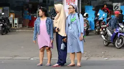 Momen ketika biarawati bergandeng tangan dengan wanita berkerudung saat menyeberangi jalan di kawasan Lenteng Agung, Jakarta, Rabu (18/4). Keharmonisan keduanya dapat menjadi contoh bagi masyarakat dalam menjaga kedamaian. (Liputan6.com/Immanuel Antonius)
