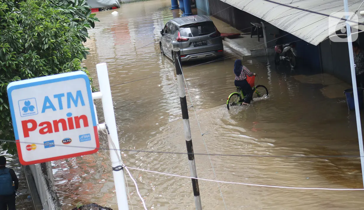 Aktivitas warga saat banjir merendam sejumlah pertokoan di sekitar Jalan Gunung Sahari, Jakarta, Selasa (25/2/2020). Hujan yang mengguyur Jakarta sejak Senin (24/2/2020) malam, membuat sejumlah kali meluap dan menyebabkan banjir. (Liputan6.com/Helmi Fithriansyah)