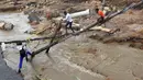 Warga berjalan melintasi jembatan darurat di atas sungai setelah sebuah jembatan hanyut di Ntuzuma, luar Durban, Afrika Selatan, 12 April 2022. Hujan berkepanjangan dan banjir di Provinsi KwaZulu-Natal Afrika Selatan telah merenggut nyawa setidaknya 20 orang, menurut pejabat setempat. (AP Photo/Str)