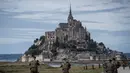 Tentara "Sentinelle" berpatroli di jalan menuju Mont-Saint-Michel di Normandia, Prancis barat laut (31/8/2019). Jalan akses ke Mont Saint Michel akan terlihat jika air laut surut dan akan hilang saat air laut pasang. (AFP Photo/Joel Saget)