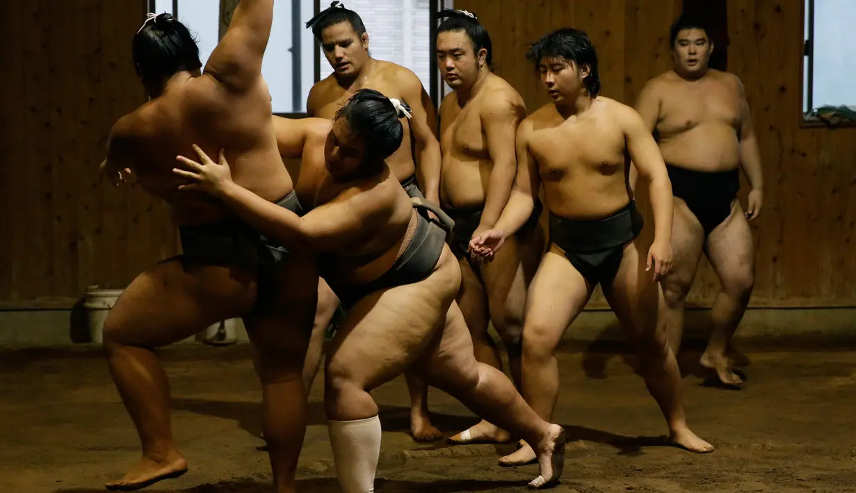 Pegulat sumo mencoba menjatuhkan lawannya saat berlatih di Musashigawa Sumo Stable di Beppu, Jepang, Jumat (18/10/2019). Sumo adalah olahraga tradisional Jepang. (AP Photo/Aaron Favila)