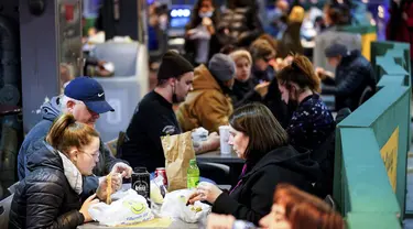 Pelanggan makan di Reading Terminal Market di Philadelphia, Rabu (16/2/2022). Pejabat kota Philadelphia mencabut mandat vaksin untuk makan di dalam ruangan dan tempat lain yang menyajikan makanan dan minuman, tetapi mandat masker dalam ruangan tetap berlaku. (AP Photo/Matt Rourke)