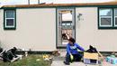Seorang wanita duduk di depan rumahnya yang rusak usai dilanda tornado di Laramie County, Wyoming, AS (29/5). Akibat tornado ini delapan properti dan rumah rusak berat. (Jacob Byk/The Wyoming Tribune Eagle via AP)