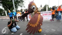 Aktivis berkostum burung saat mengelar aksi teatrikal di titik nol km, Yogyakarta, (14/9). Dalam aksinya mereka menentang perburuan satwa liar khususnya dengan menggunakan senapan angin. (Liputan6.com/Boy harjanto)