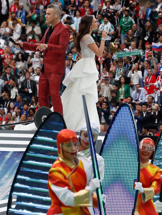 Penyanyi asal Inggris, Robbie Williams, berduet dengan penyanyi soprano Rusia Aida Garifullina pada upacara pembukaan Piala Dunia 2018 di Stadion Luzhniki, Moskow, Kamis (14/6). Keduanya berkolaborasi di lagu Angel milik Williams. (AP/Antonio Calanni)