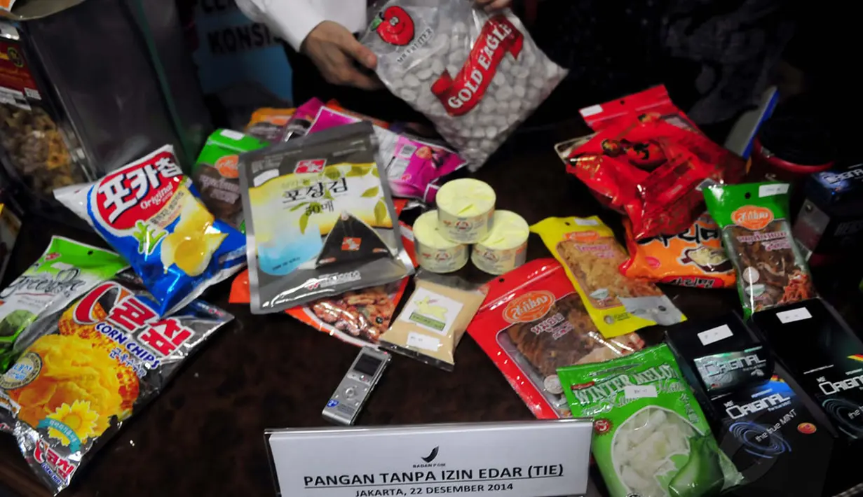 Produk yang menjadi target pengawasan adalah pangan Tanpa Izin Edar (TIE), kadaluwarsa, dalam kondisi rusak. Salah satu petugas menunjukkan kemasan produk pangan Tanpa Izin Edar (TIE) di Jakarta, Senin (22/12/2014). (Liputan6.com/Johan Tallo)