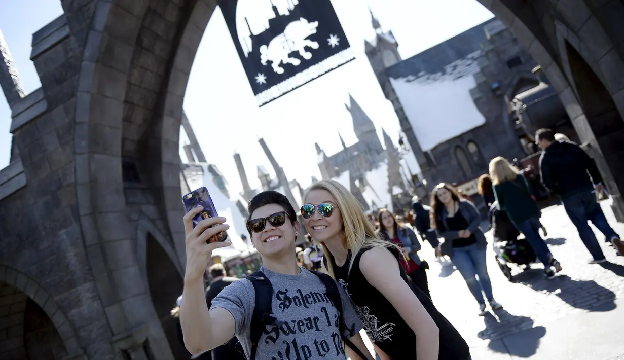 Pengunjung berselfie sebelum memasuki desa Hogsmeade dalam soft opening dan tur media taman bermain bertemakan "The Wizarding World of Harry Potter" di Universal Studios.
