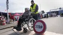Seorang pria mendorong seorang perempuan di kursi roda melintasi perbatasan di Vysne Nemecke, Slovakia, 3 Maret 2022. Badan pengungsi PBB , UNHCR pada Kamis (3/3) melaporkan 1 juta orang telah meninggalkan Ukraina sejak invasi Rusia sepekan lalu. (AP Photo Darko Vojinovic)