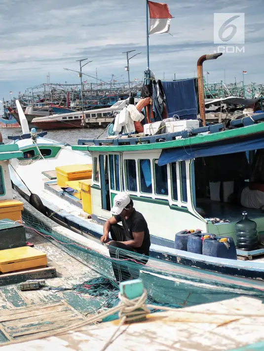 Nelayan memperbaiki jaring di Pelabuhan Muara Angke, Jakarta, Kamis (27/12). Akibat tak bisa melaut, nelayan mengandalkan koperasi untuk simpan pinjam menutupi kebutuhan sehari-hari. (Liputan6.com/Faizal Fanani)
