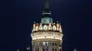 Pemandangan supermoon terlihat di belakang puncak gedung pencakar langit era Stalin di Moskow, Rusia, Selasa (7/4/2020). Fenomena dimana bulan berada pada titik terdekat dengan bumi ini merupakan penampakan supermoon terbesar di tahun 2020. (Dimitar DILKOFF/AFP)
