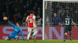 Kiper Real Madrid, Thibaut Courtois menyelamatkan gawangnya saat menghadapi Ajax pada leg pertama 16 besar Liga Champions di Johan Cruijff ArenA, Amsterdam, Rabu (13/2). Real Madrid harus bersusah payah menaklukkan Ajax dengan skor 2-1. (AP/Peter Dejong)