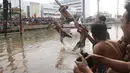 Seorang peserta terjatuh saat mengikuti lomba panjat pinang dalam Festival Kalimalang di Cipinang Melayu, Jakarta Timur, Kamis (17/8). Festival Kalimalang ini dalam rangka memeriahkan HUT ke-72 RI. (Liputan6.com/Herman Zakharia)